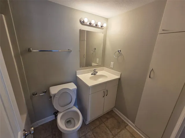 a bathroom with a granite countertop toilet and a sink