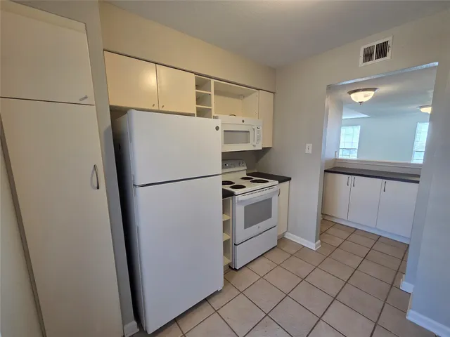 a kitchen with a stove cabinets and refrigerator