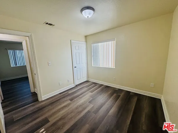 a view of a hallway with wooden floor and stairs
