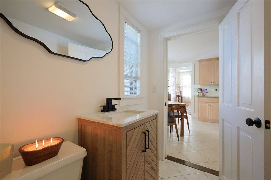 107 Minot Street Boston, MA 02122 - Photo 30 of 42 a bathroom with a sink a toilet a mirror and vanity