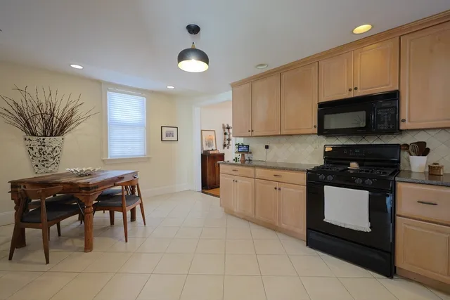 a kitchen with stainless steel appliances granite countertop a stove a sink a microwave and a refrigerator