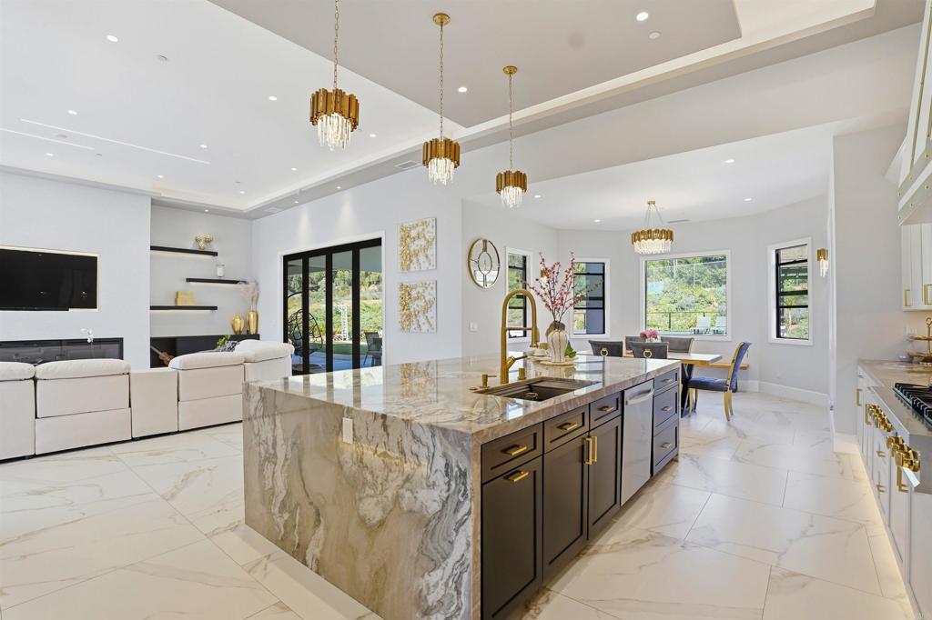 14989 Orchard View Drive Poway, CA 92064 - Photo 19 of 50 a kitchen with stainless steel appliances kitchen island granite countertop a stove and a sink