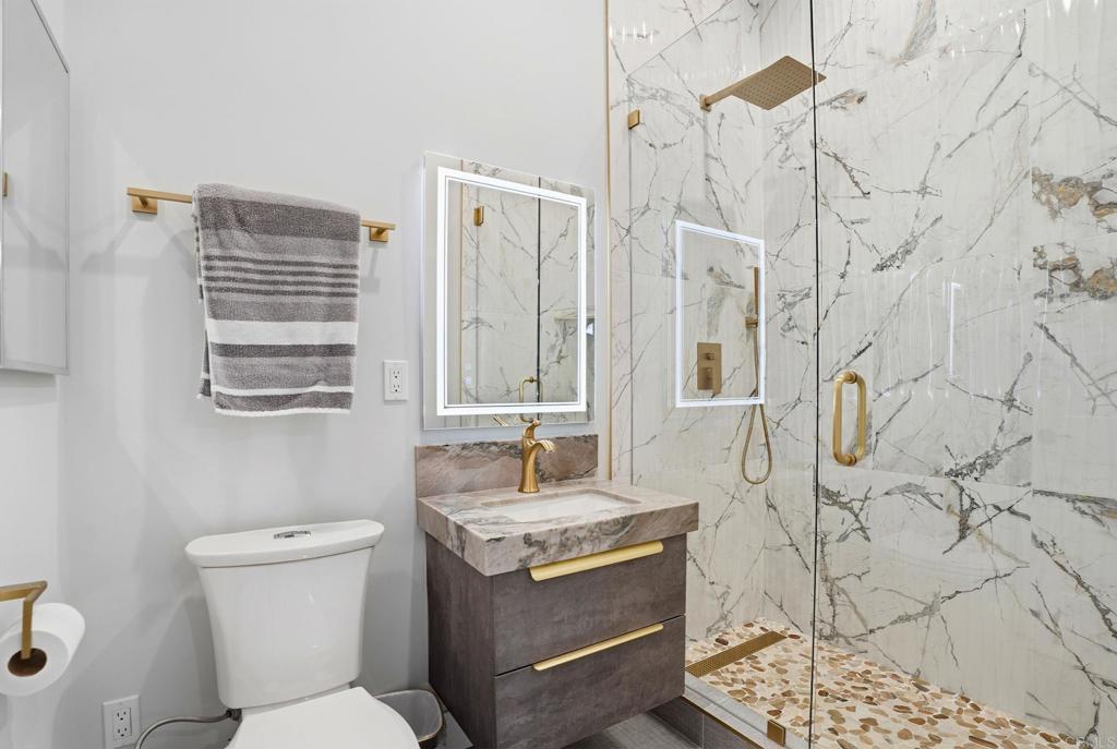 14989 Orchard View Drive Poway, CA 92064 - Photo 31 of 50 a bathroom with a granite countertop sink a toilet and shower curtain