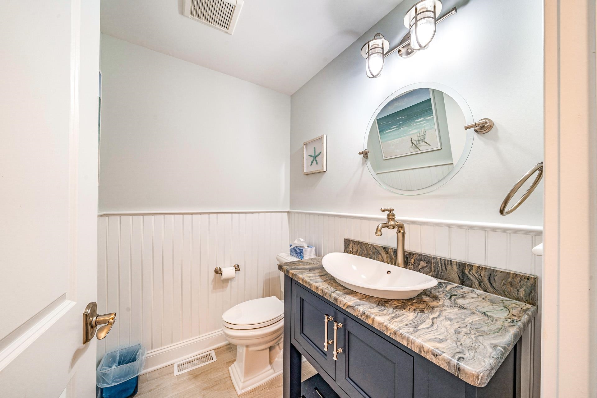7418 Dune Drive Avalon, NJ 08202 - Photo 36 of 50 a bathroom with a granite countertop sink a toilet and a mirror