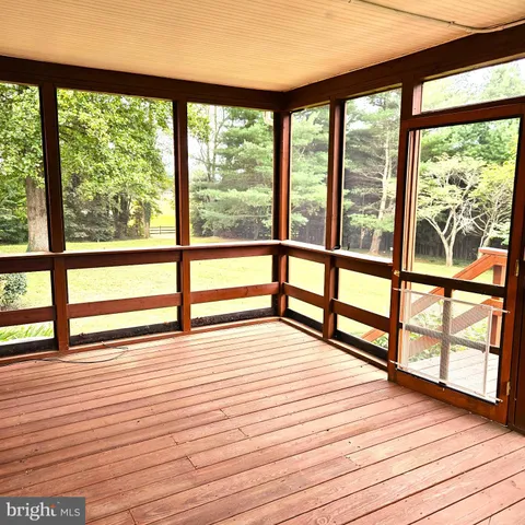 a view of empty room with wooden floor and large windows