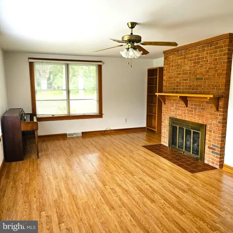 a view of a livingroom with a fireplace and wooden floor