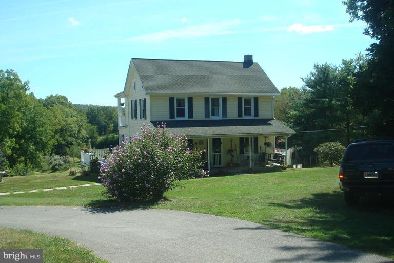 a aerial view of a house next to a big yard and large trees