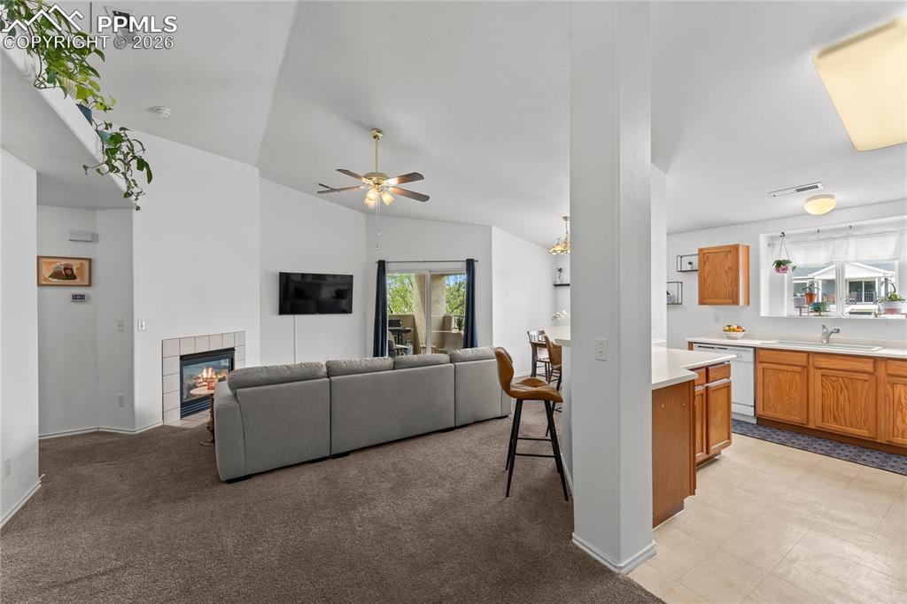 3976 Riviera Grove, Unit 203 Colorado Springs, CO 80922 - Photo 3 of 45 a living room with furniture a flat screen tv and kitchen view