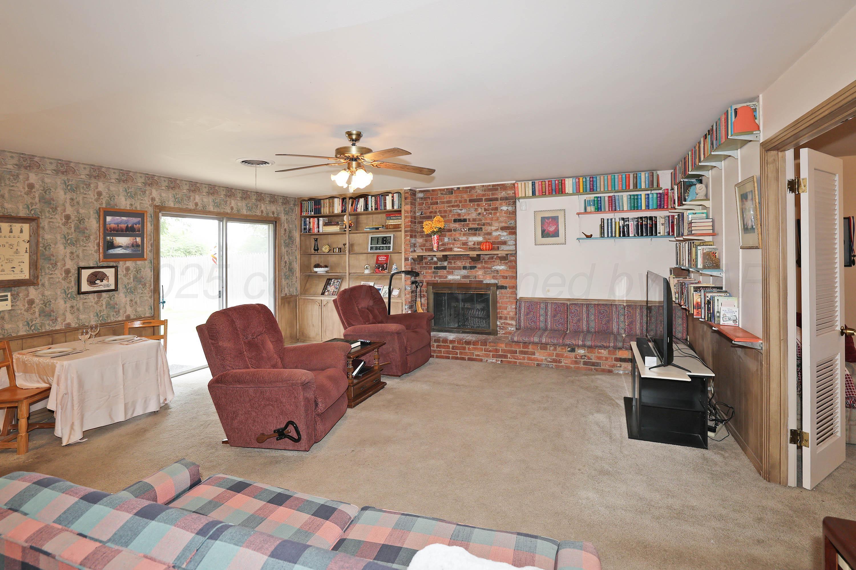 2816 Lloyd Drive Amarillo, TX 79110 - Photo 6 of 29 a living room with furniture a chandelier and a bookshelf