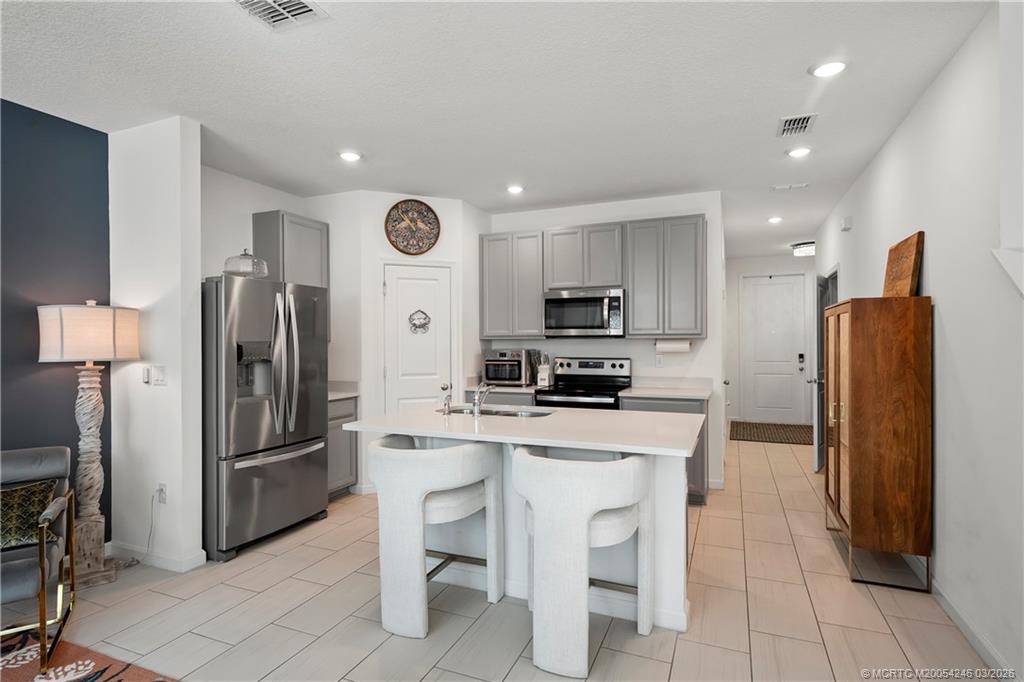 380 Southeast Sea Hunt Way Stuart, FL 34994 - Photo 8 of 42 a kitchen with stainless steel appliances a refrigerator stove microwave and cabinets