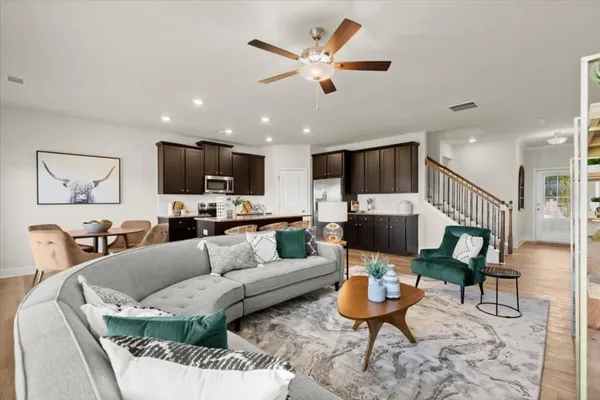 a living room with furniture kitchen view and a flat screen tv