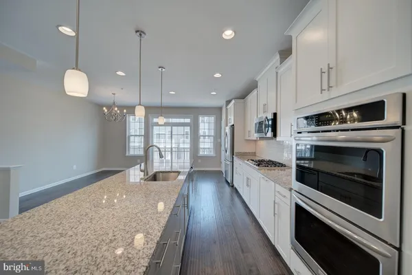 a large kitchen with stainless steel appliances granite countertop lots of counter space a sink and appliances