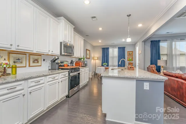 a kitchen with stainless steel appliances granite countertop a sink and cabinets
