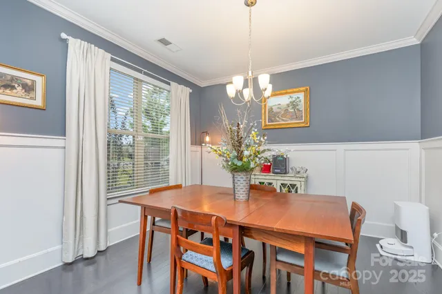 a dining room with furniture a chandelier and wooden floor