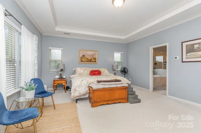 a bed room with a bed a couch and potted plant