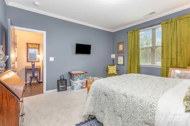 a bedroom with a bed and large windows