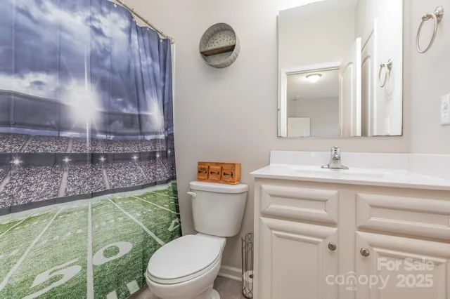 a bathroom with a toilet a sink and mirror