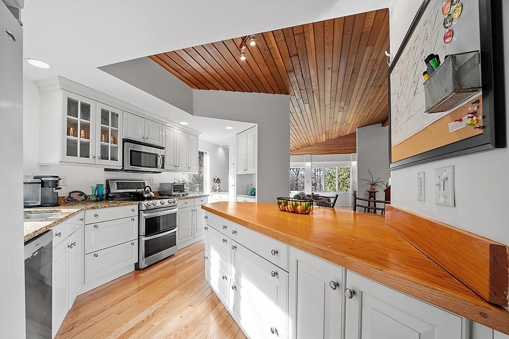 10 Orch Hl Road Harvard, MA 01451 - Photo 6 of 33 a kitchen with stainless steel appliances granite countertop a sink dishwasher stove and refrigerator with wooden floor