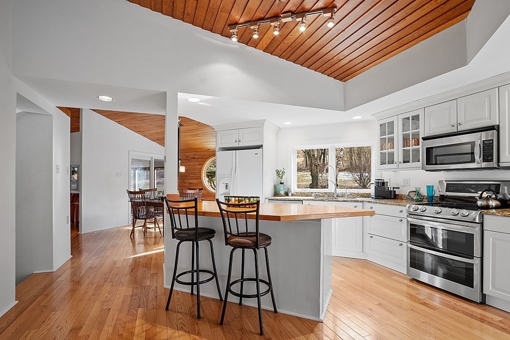 10 Orch Hl Road Harvard, MA 01451 - Photo 7 of 33 a kitchen with stainless steel appliances a table chairs and wooden floor