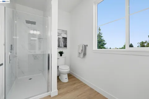 a bathroom with a granite countertop bathtub shower and a toilet
