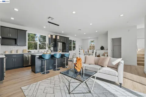 a living room with lots of furniture and kitchen view