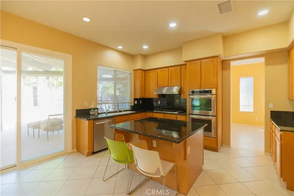 a kitchen with stainless steel appliances granite countertop a sink and a refrigerator