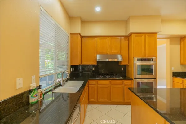 a kitchen with stainless steel appliances wooden floor and a large window