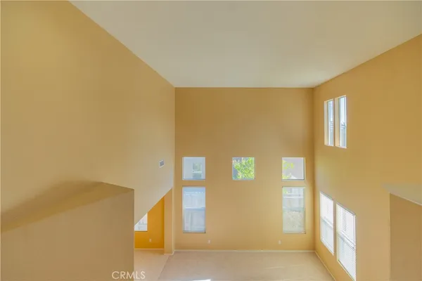 a view of an empty room with wooden floor and a bathroom