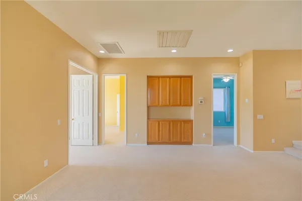 a view of a big room with windows and ceiling fan