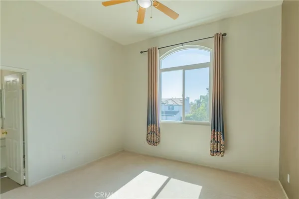 an empty room with closet and a chandelier fan