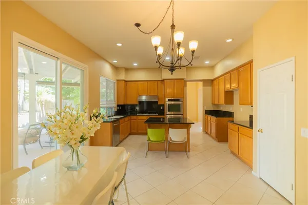 a view of a dining room with furniture a chandelier and wooden floor