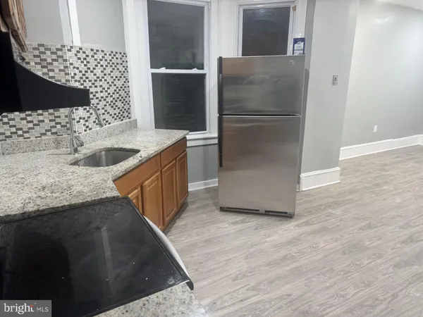 a kitchen with stainless steel appliances kitchen island granite countertop a refrigerator and a sink