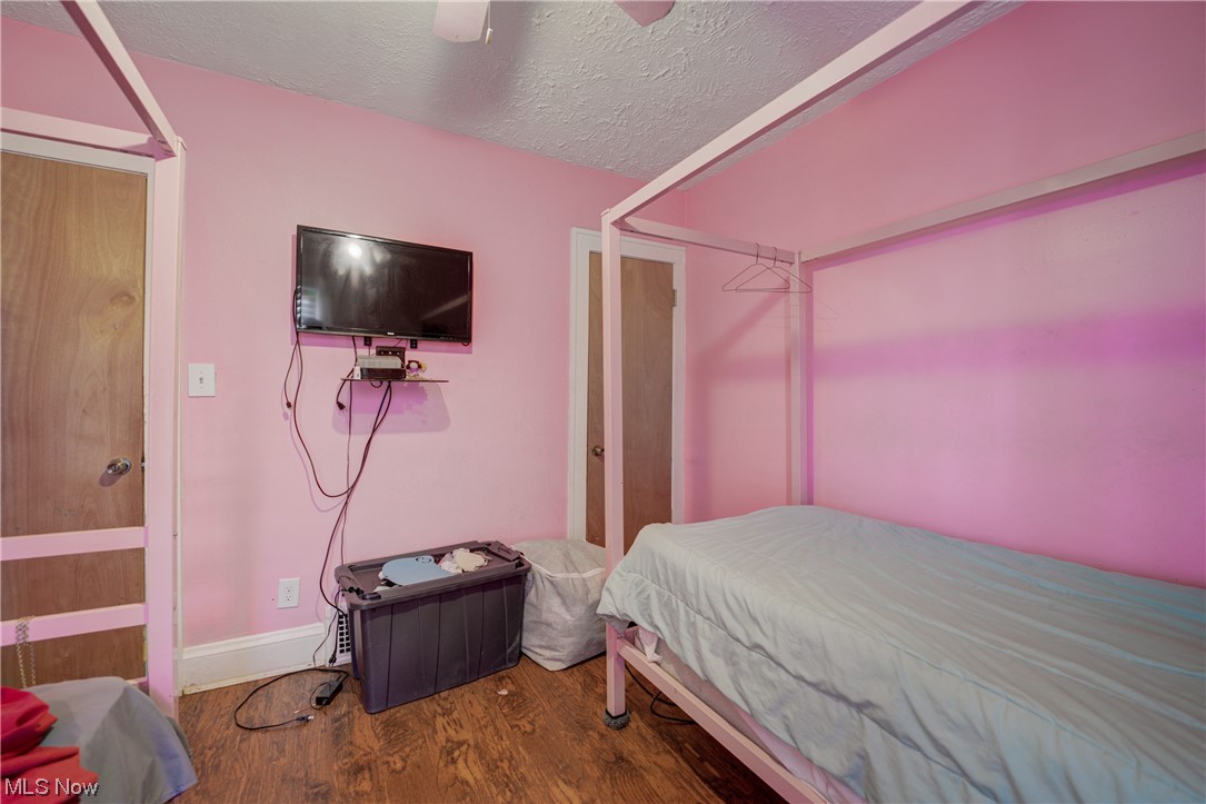 14202 Glenside Road Cleveland, OH 44110 - Photo 14 of 41 Bedroom featuring dark wood-type flooring, ceiling fan, and a textured ceiling