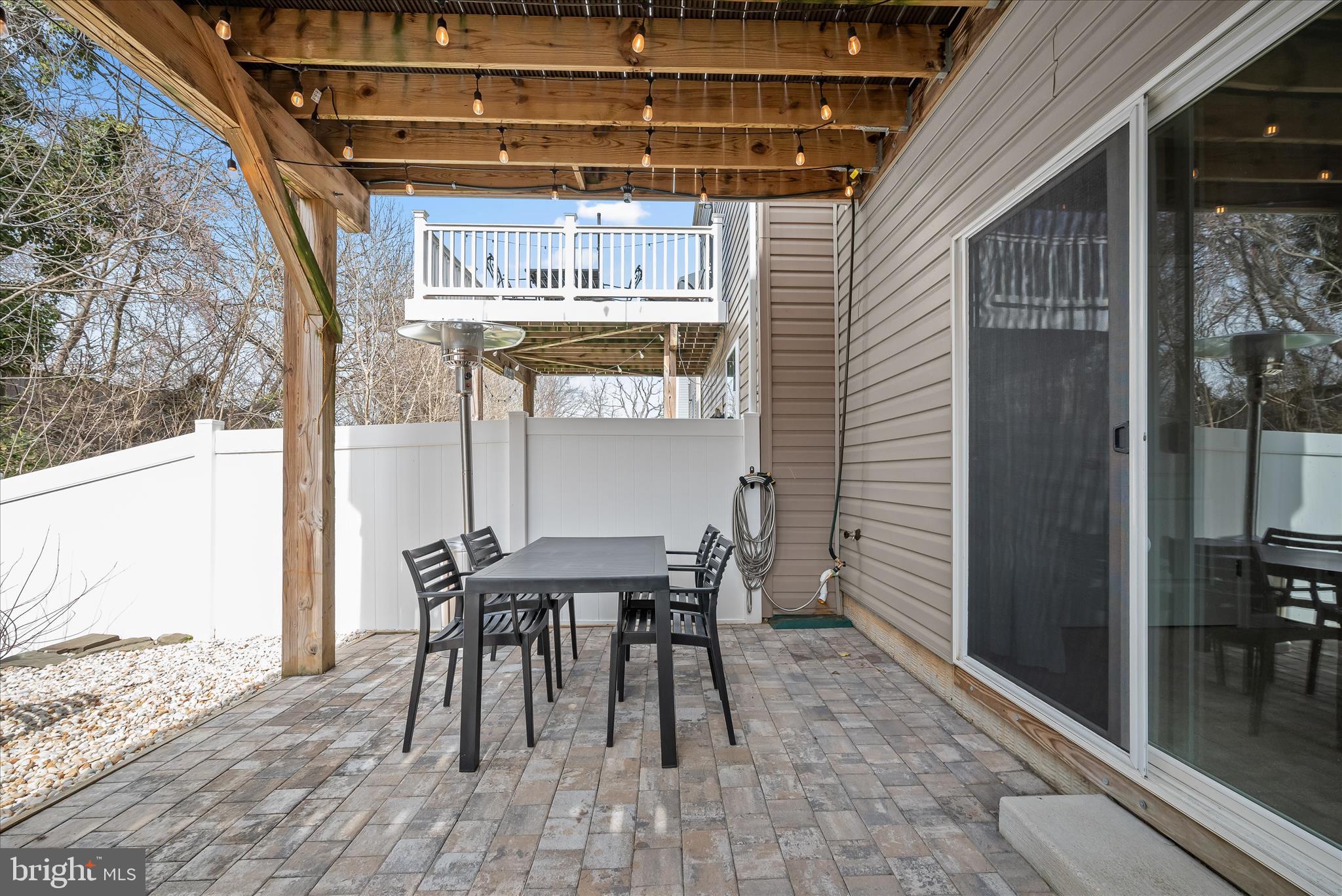 9890 Deer Run Laurel, MD 20723 - Photo 34 of 47 a view of a patio with a table and chairs and floor to ceiling window with wooden floor