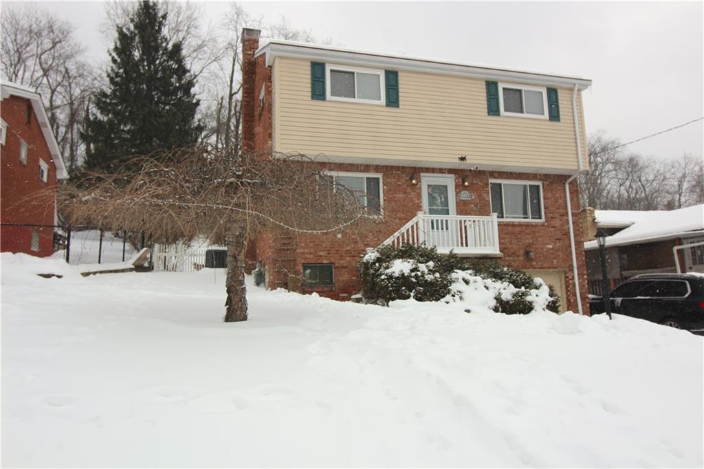 a front view of a house with a yard covered in snow