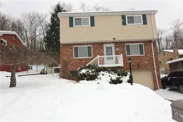 a view of a house with a yard covered in snow