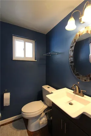 a bathroom with a sink mirror vanity and toilet