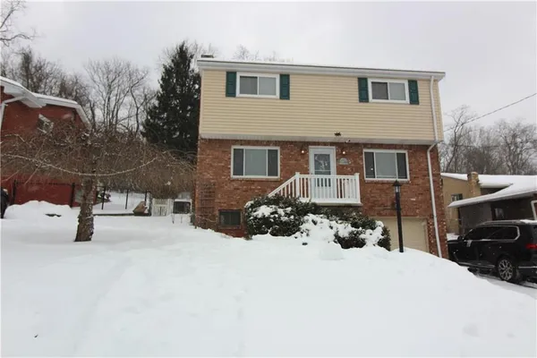 a view of a house with a yard covered in snow