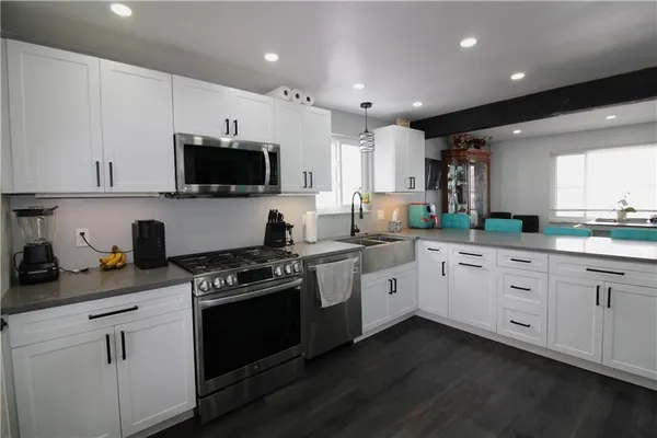 a kitchen with granite countertop white cabinets and white appliances