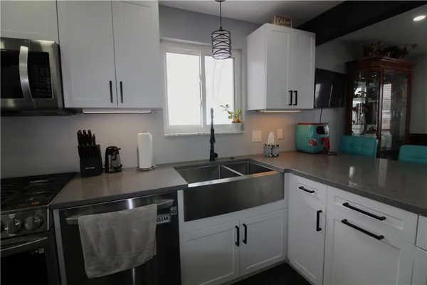 a kitchen with stainless steel appliances a sink stove and cabinets