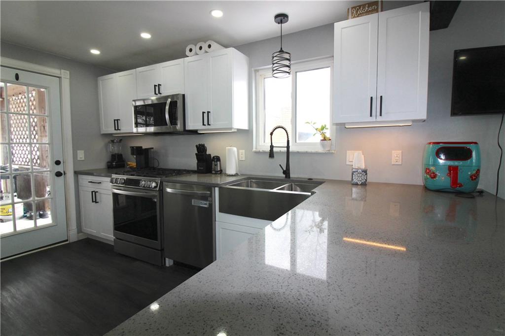 5877 Pleasant Street South Park, PA 15129 - Photo 9 of 34 a kitchen with stainless steel appliances granite countertop a sink a stove top oven a counter space and cabinets