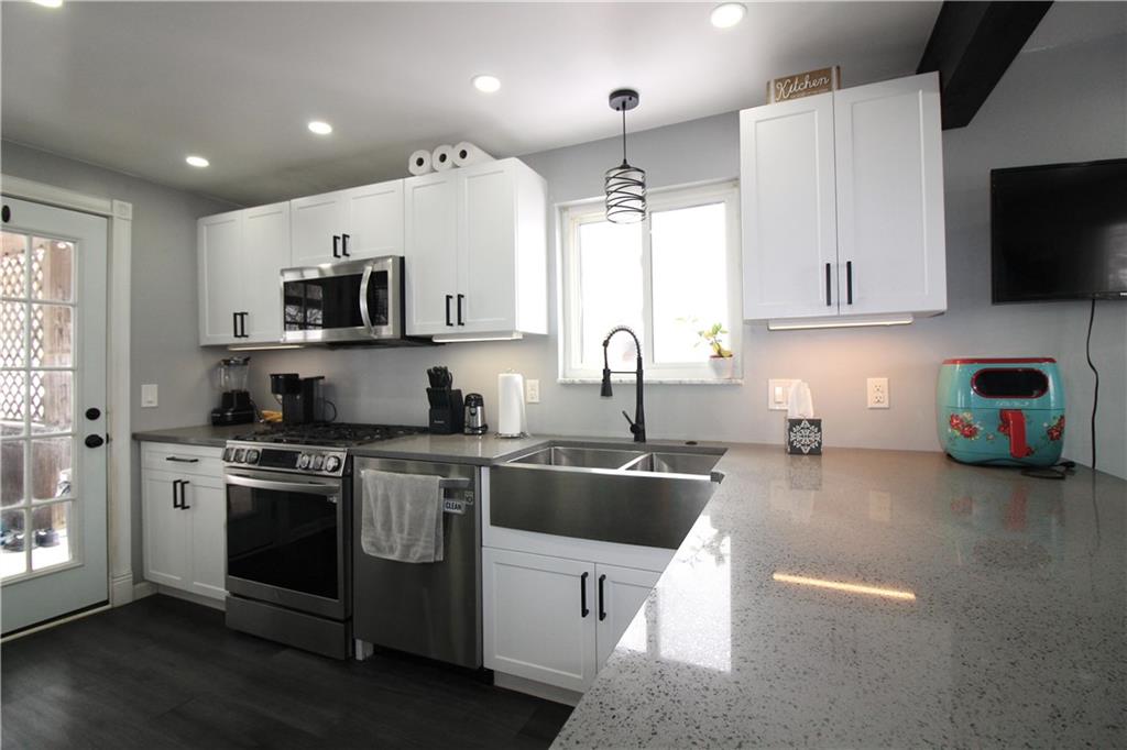 5877 Pleasant Street South Park, PA 15129 - Photo 10 of 34 a kitchen with stainless steel appliances a stove a sink a microwave a refrigerator and cabinets