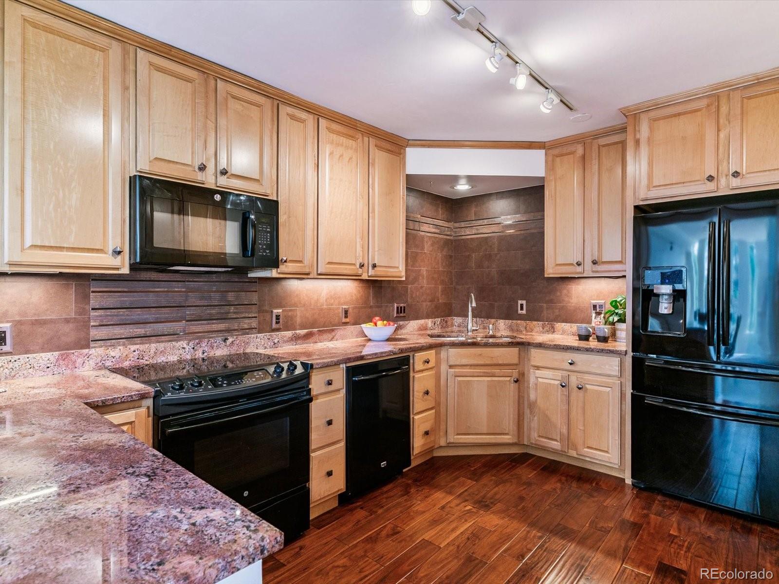 1111 Race Street, Unit 3A Denver, CO 80206 - Photo 12 of 39 a kitchen with stainless steel appliances granite countertop a stove sink microwave and refrigerator