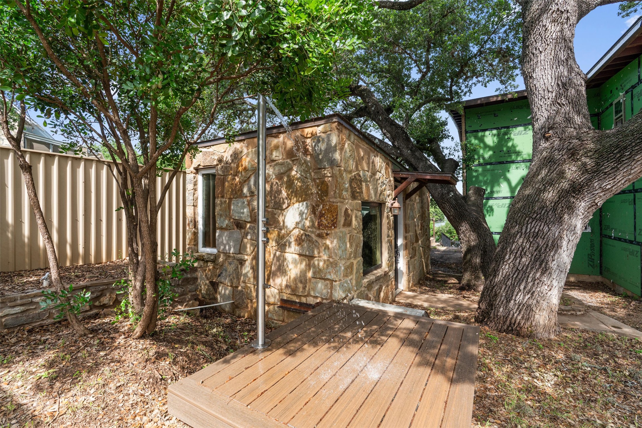 325 Eagle Rest Burnet, TX 78611 - Photo 22 of 40 An outdoor shower and wooden deck create a secluded oasis nestled among mature trees.