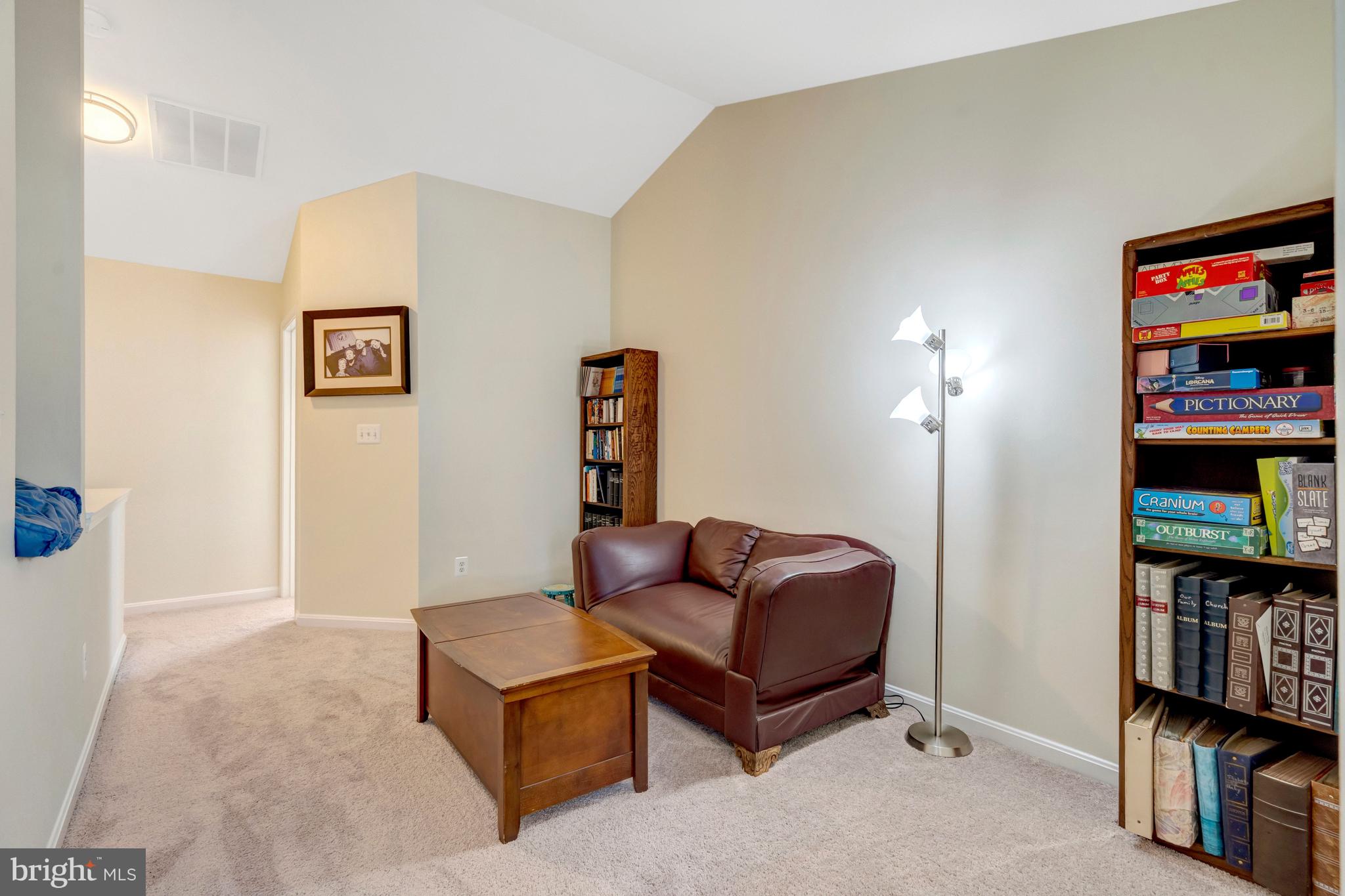 43546 Mink Meadows Street Chantilly, VA 20152 - Photo 39 of 48 a living room with furniture a bookshelf and a flat screen tv