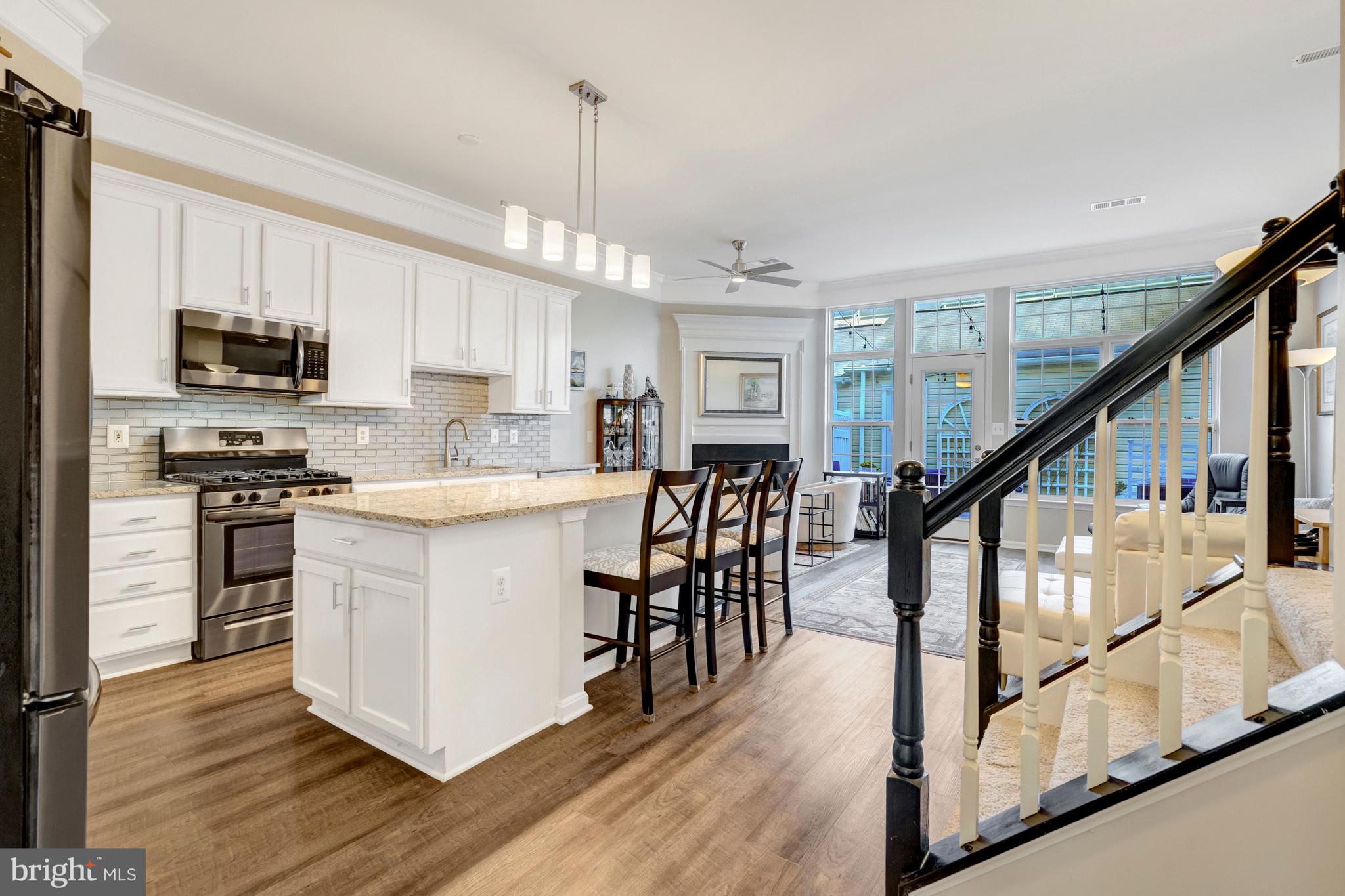 43546 Mink Meadows Street Chantilly, VA 20152 - Photo 9 of 48 a kitchen with stainless steel appliances kitchen island wooden floors and white cabinets