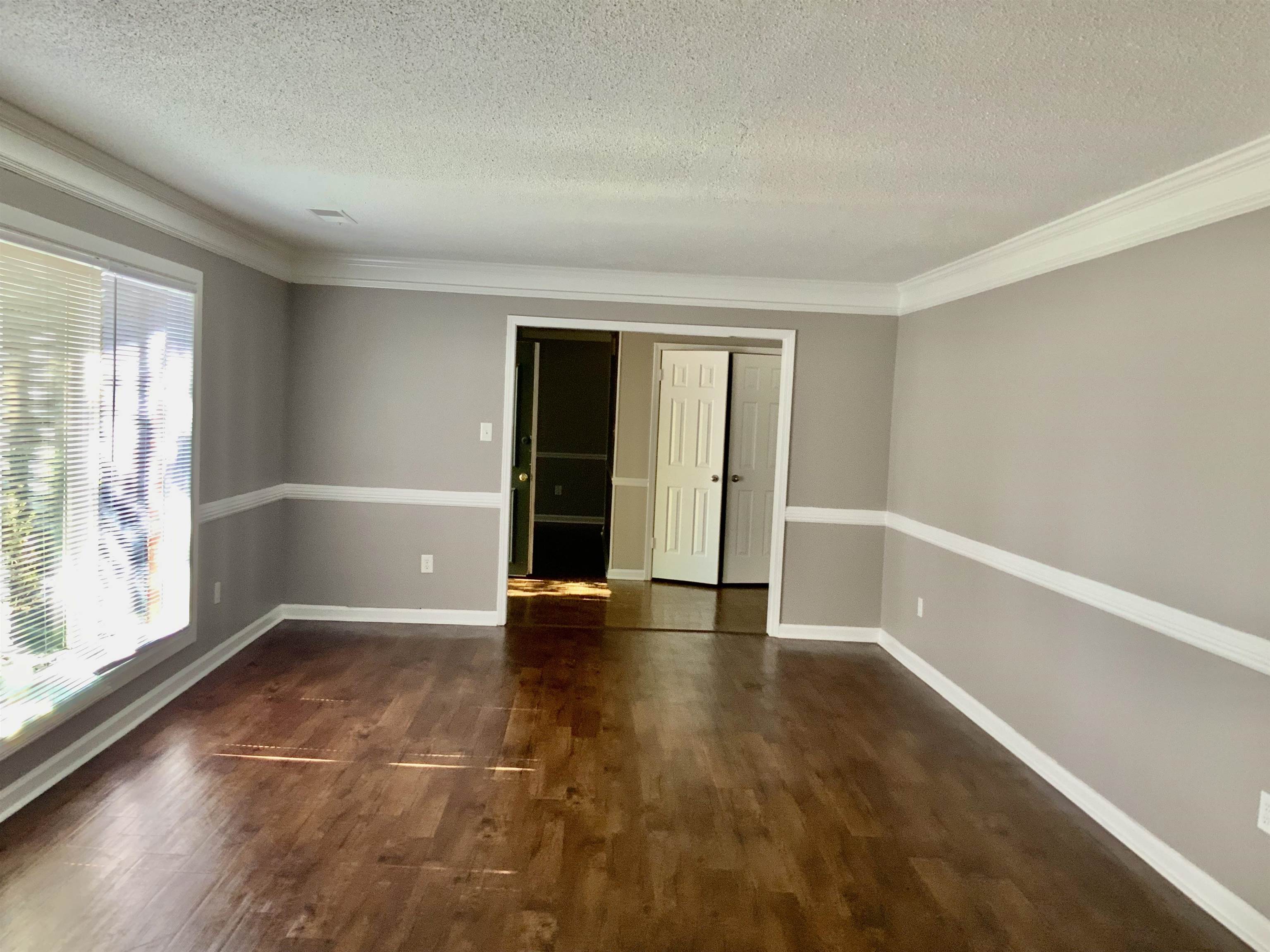 83 South Walnut Bend Road Memphis, TN 38018 - Photo 5 of 24 wooden floor in an empty room with a window