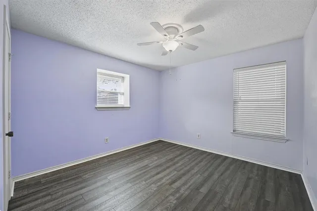 a view of a room with wooden floor and fan
