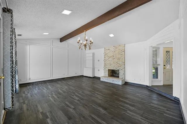 a view of a livingroom with wooden floor a fireplace and window