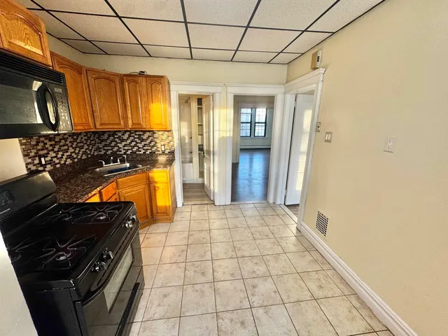 a kitchen with stainless steel appliances granite countertop a refrigerator and a stove top oven